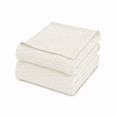 Folded cream waffle-weave cotton thermal blanket.