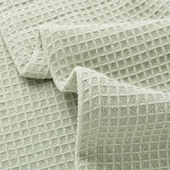 Close-up of pale green waffle-weave blanket fabric.