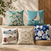 Five cushion covers with turquoise, navy and cream bird, fish and floral designs.