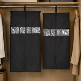 Two black hanging garment covers with clear window strips suspended from a metal wardrobe rod.
