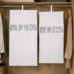 Two white hanging garment covers with clear window strips suspended from a metal wardrobe rod.