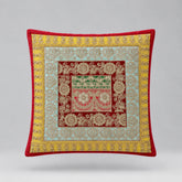 Red-bordered cushion cover with yellow and pale green floral borders around a patterned red centre.