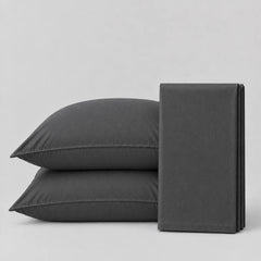 Plain Cotton Satin Bedsheet Set Charcoal Grey ewith pillows on a light grey surface