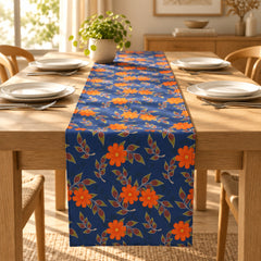Navy table runner with orange flowers and leafy stems.