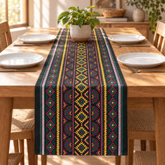 Dark striped table runner with colourful geometric diamond motifs.
