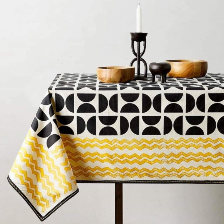 Black, white and mustard geometric tablecloth with a contrasting patterned border.