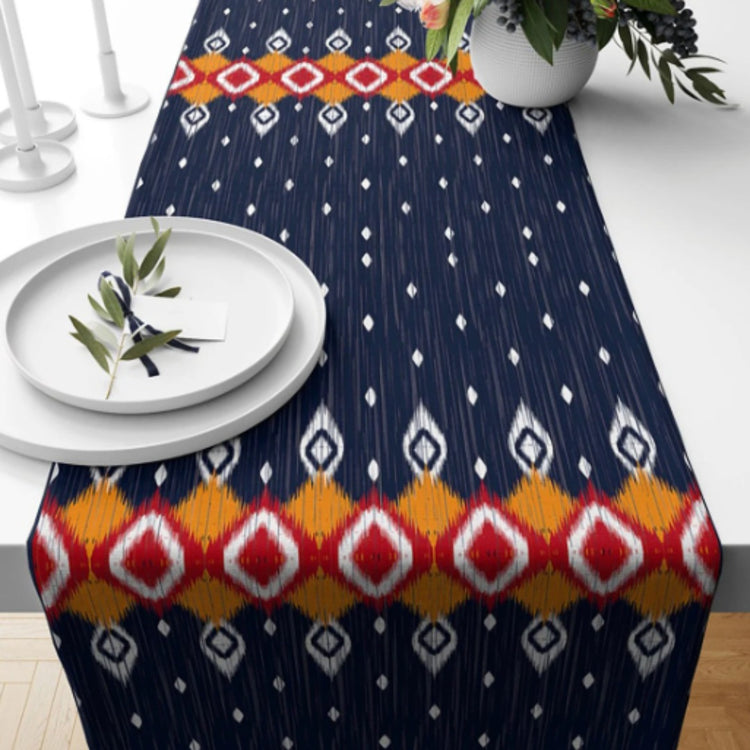 Navy table runner with small cream motifs and a colourful diamond border.