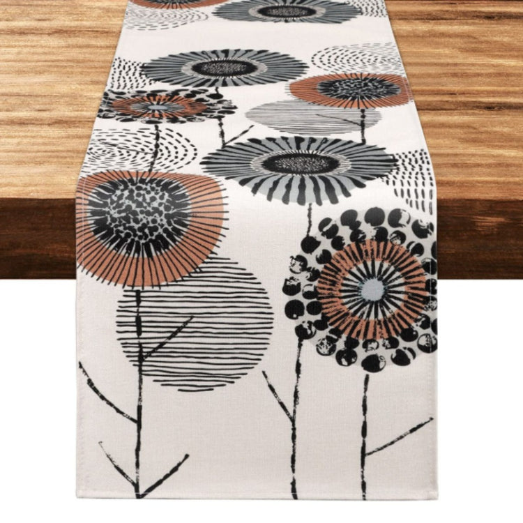 Cream table runner with stylised black, grey and orange flowers.