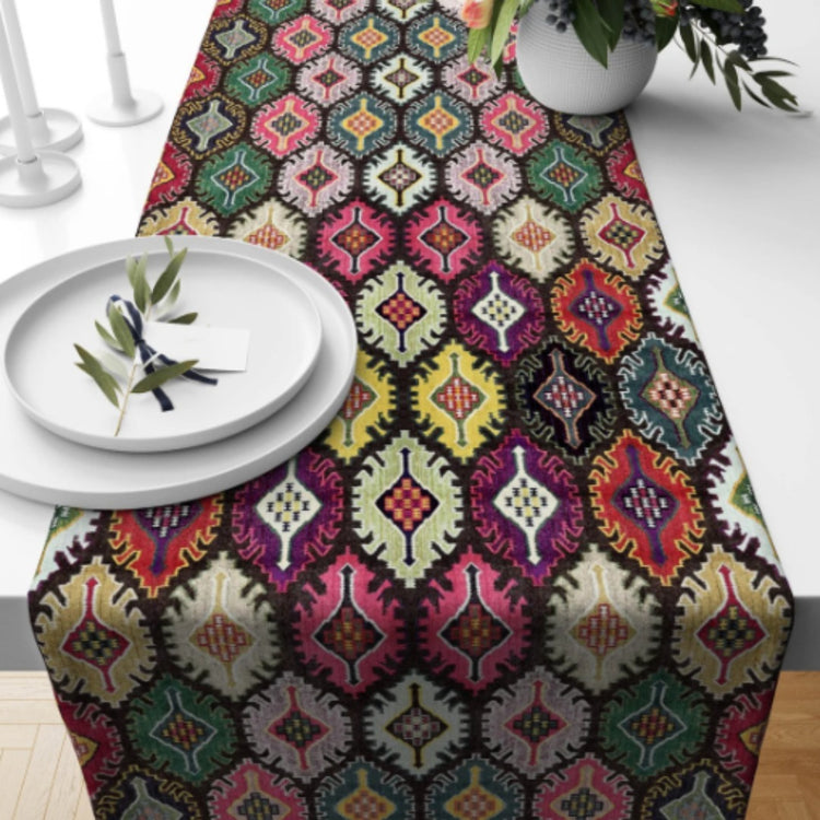 Dark table runner with small multicoloured geometric medallions.