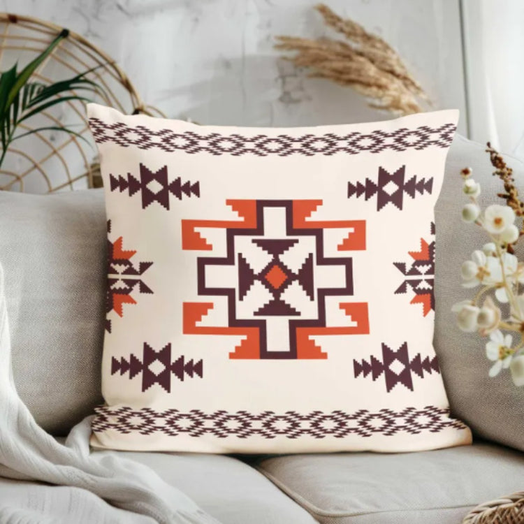 Cream cushion cover with a central rust and brown geometric star and small border motifs.