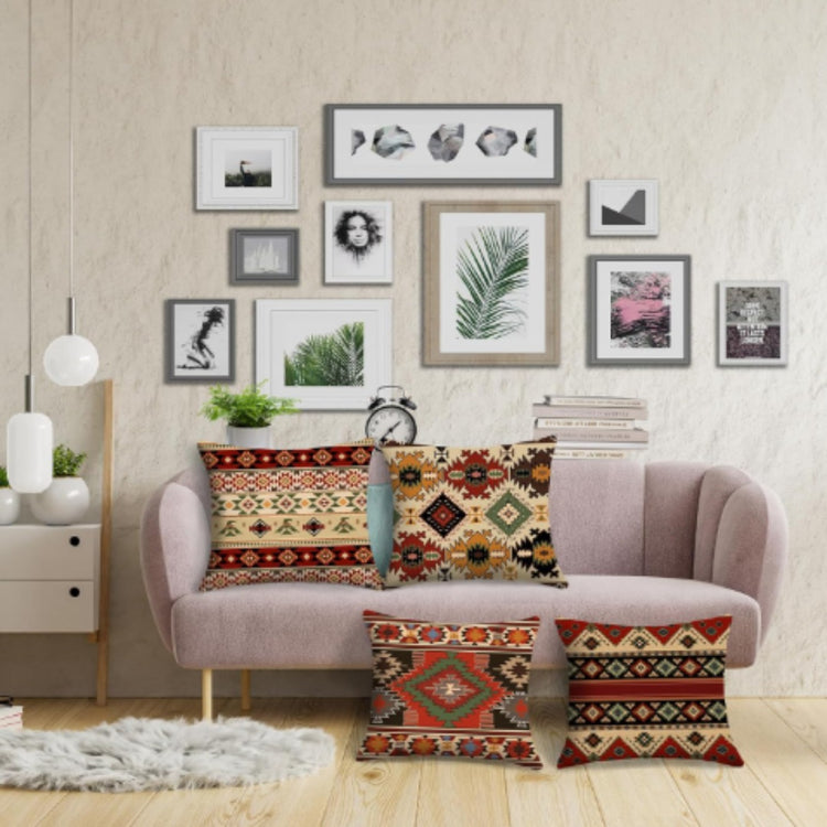 Four colourful geometric cushion covers displayed on a pink sofa and floor.