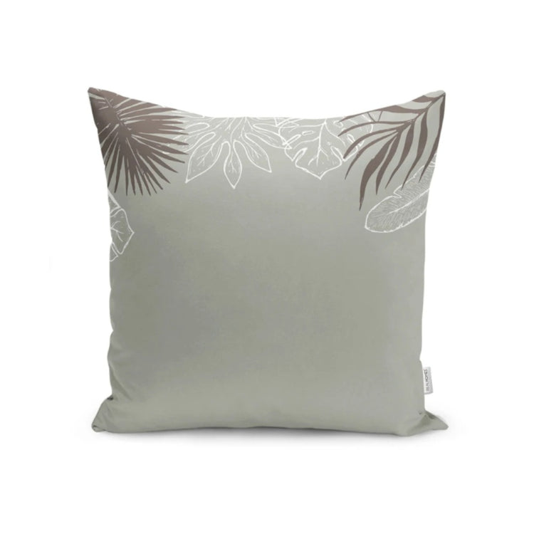 Sage green cushion cover with pale leaf outlines along the top corners.