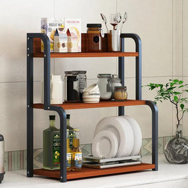 Compact black-frame kitchen shelf rack with brown shelves holding jars, plates and utensils.