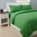 Bright green textured blanket with matching pillow covers on a bed.