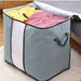 Open grey fabric storage bag holding folded clothes.
