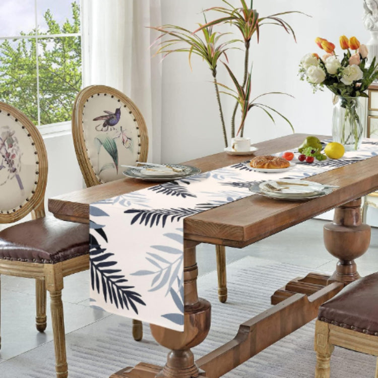 White table runner with dark blue leaf silhouettes.