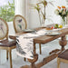 White table runner with grey leaf silhouettes.