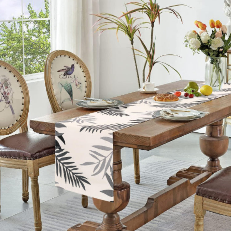 White table runner with grey leaf silhouettes.