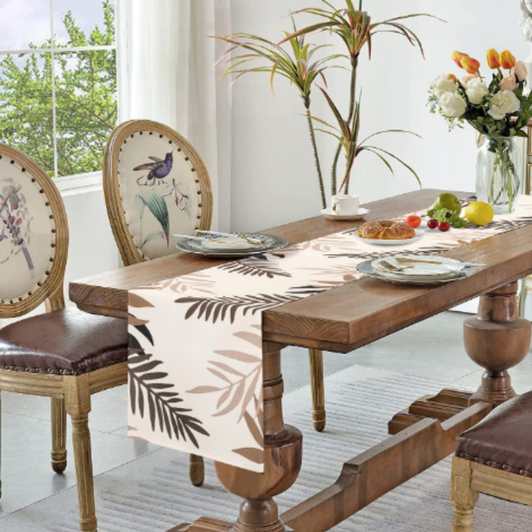 White table runner with brown leaf silhouettes.