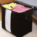 Open black fabric storage bag holding folded clothes.
