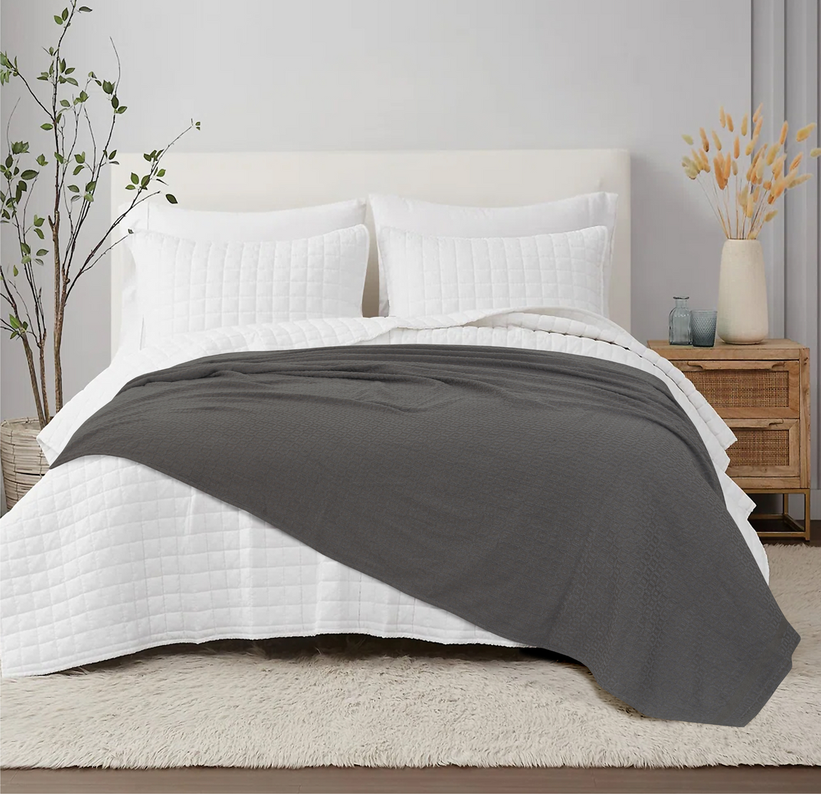 Charcoal grey cotton thermal blanket spread across a bed.