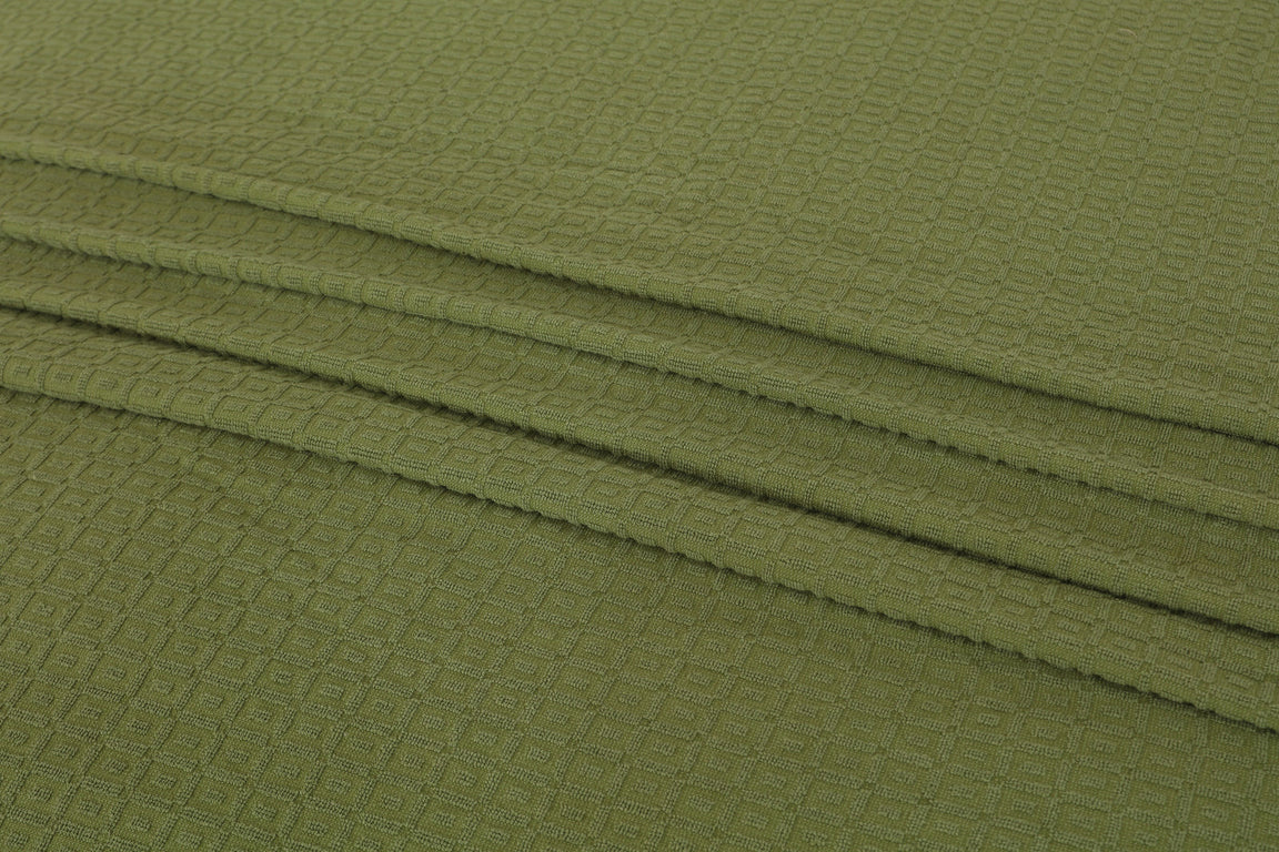 Close-up of olive green cotton thermal blanket fabric.