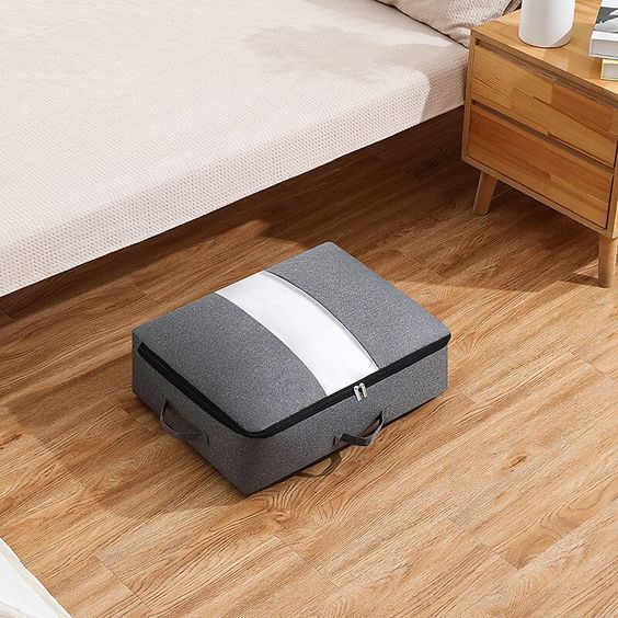 Grey flat quilt-storage bag beside a bed.