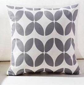 White cushion cover with a repeating grey petal lattice pattern.