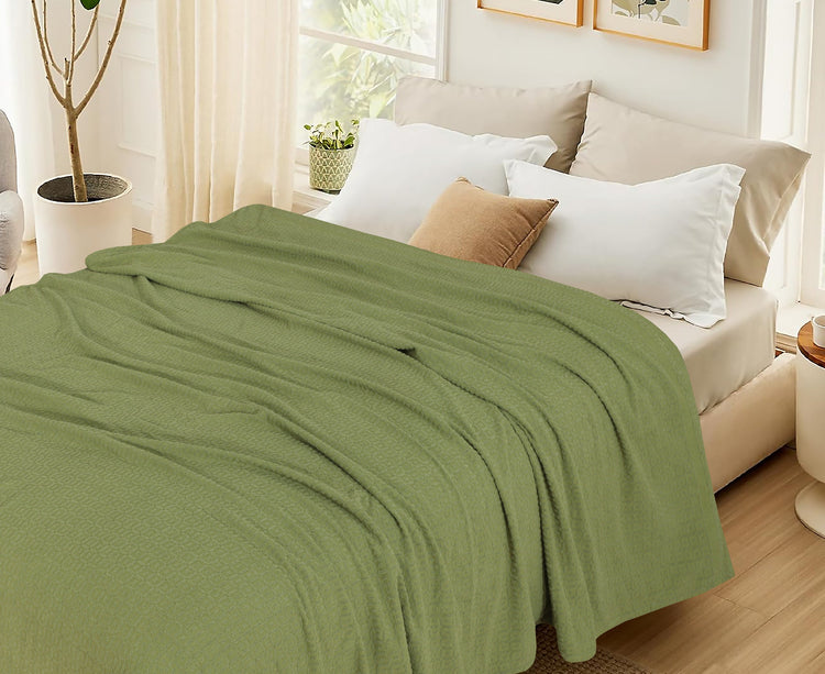 Olive green cotton thermal blanket spread across a bed.