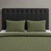 Olive green waffle-weave blanket and matching pillow covers on a bed.