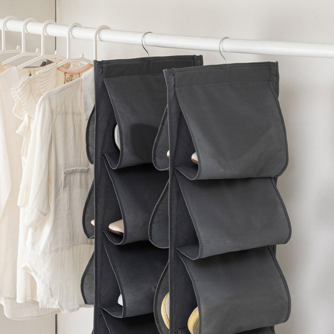 Close view of a grey shoe organizer hanging from a wardrobe rail.