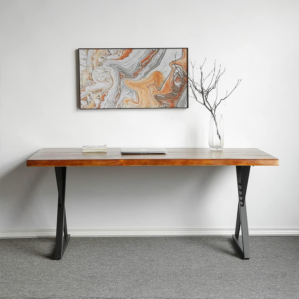 Brown-top desk with black crossed leg supports against a wall beneath abstract artwork.