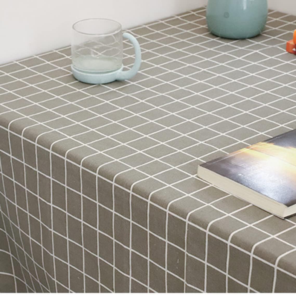 Close-up of a grey tablecloth with a white grid pattern.