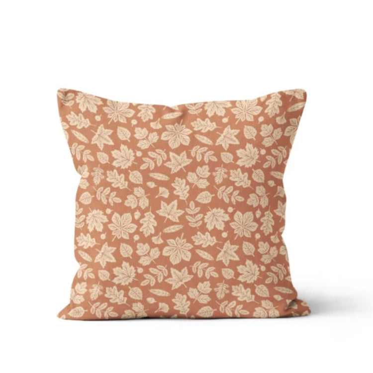 Peach cushion cover with a small repeating cream floral pattern.