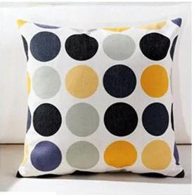 White cushion cover with rows of black, grey and yellow circles.