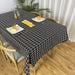 Black tablecloth with a white grid pattern on a dining table.