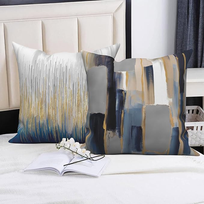 Gray, navy and gold-colored abstract cushion covers displayed on a bed