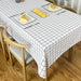 White tablecloth with a black grid pattern on a dining table.