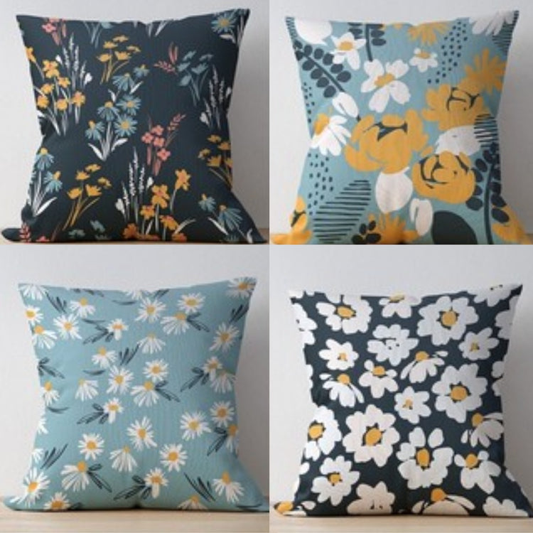 Four cushion covers with white and yellow flowers on blue and charcoal backgrounds.