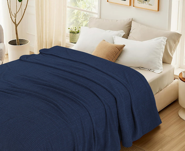 Navy cotton thermal blanket spread across a bed.