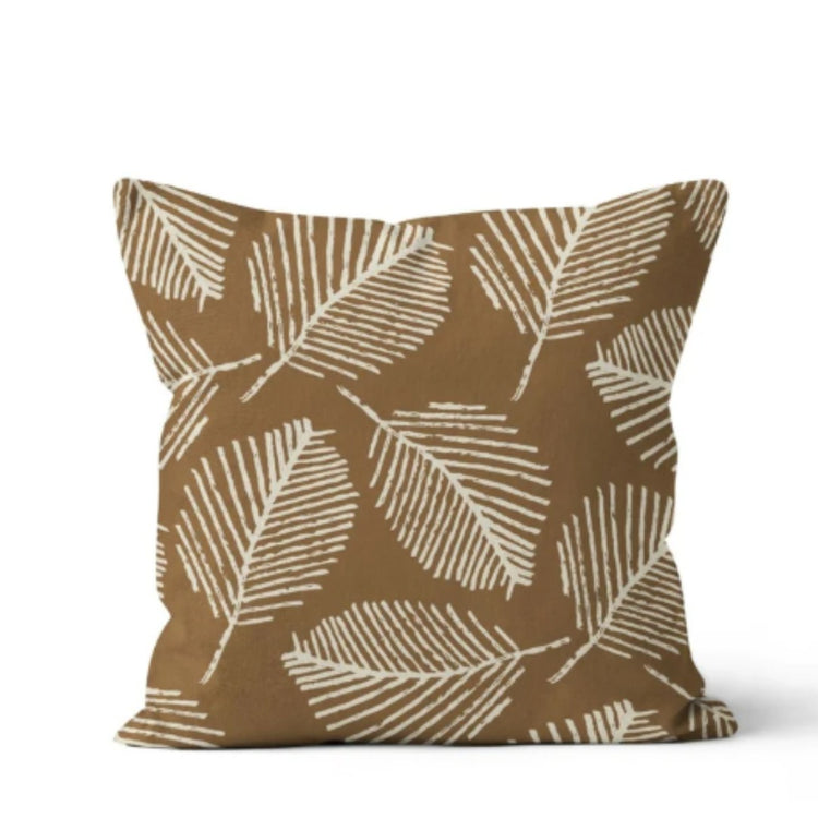 Brown cushion cover with pale leaf outlines.