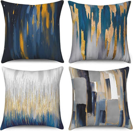 Four cushion covers with navy, grey, cream and gold coloured paint-like streaks.