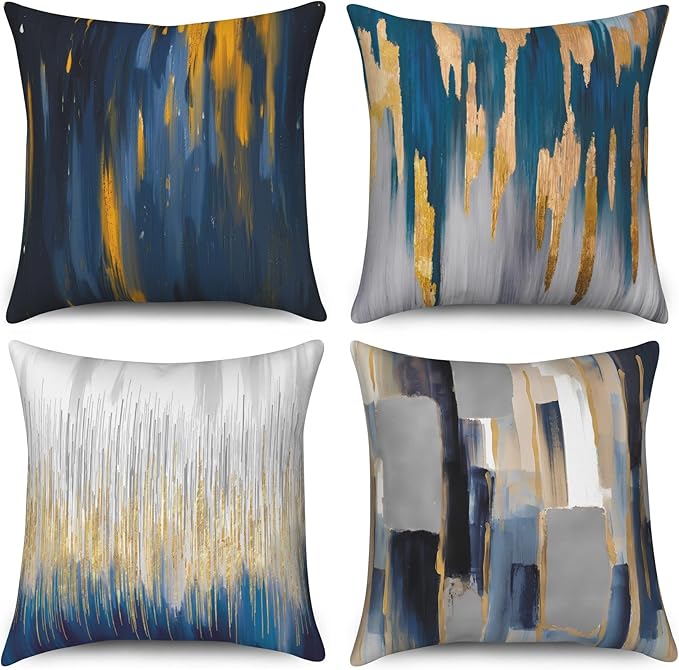 Four cushion covers with navy, grey, cream and gold coloured paint-like streaks.