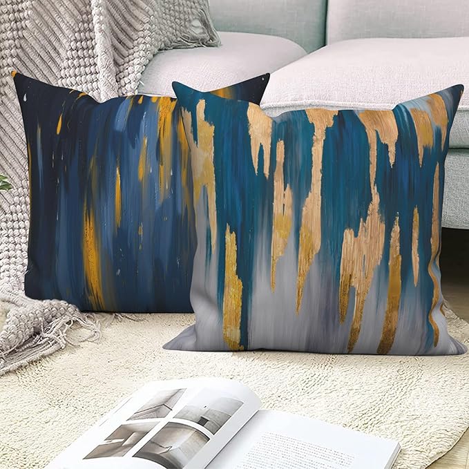 Close view of navy cushion covers with gold coloured and cream vertical brushstroke patterns.