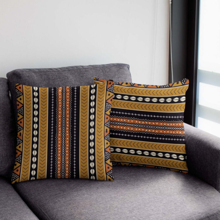 Two dark cushion covers with narrow mustard, white and black striped patterns on a chair.