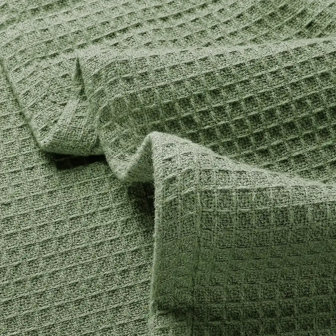 Close-up of olive green waffle-weave blanket fabric.