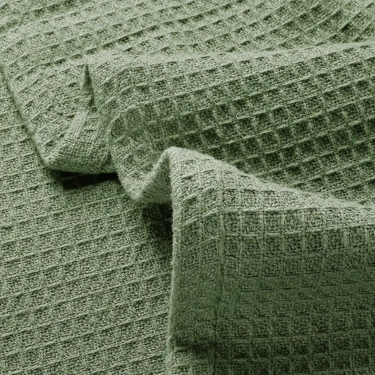 Close-up of olive green waffle-weave blanket fabric.