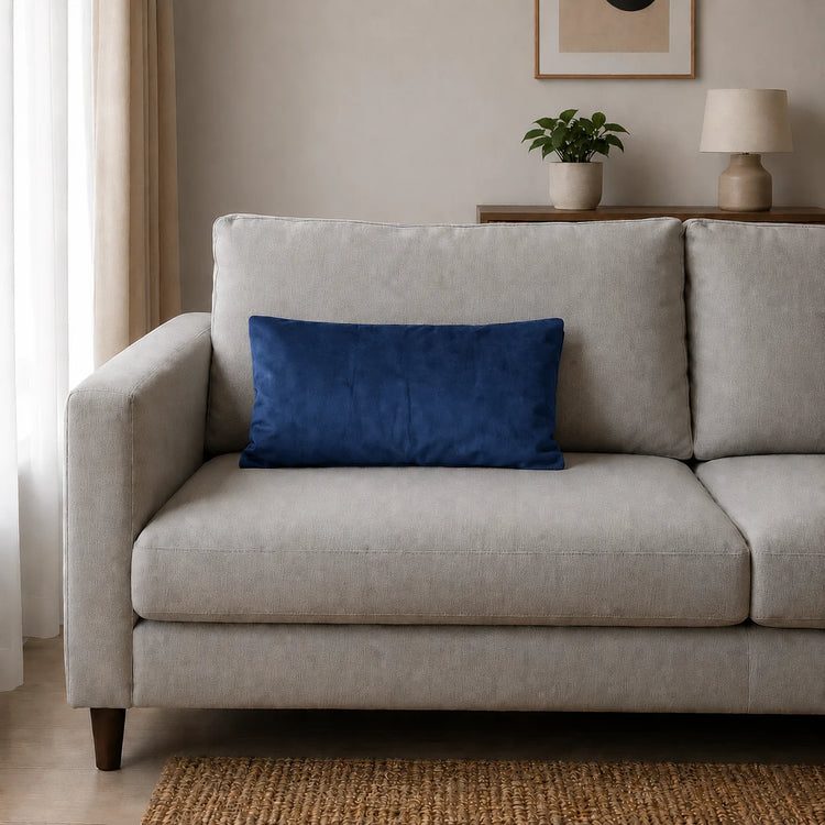 Plain rectangular blue filled cushion on a pale sofa.