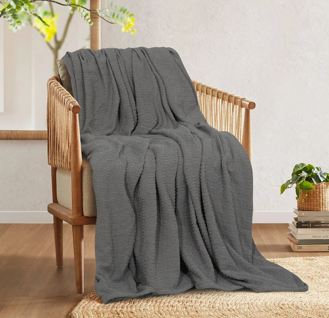 Charcoal grey cotton thermal blanket draped over a wooden armchair.