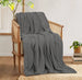 Charcoal grey cotton thermal blanket draped over a wooden armchair.